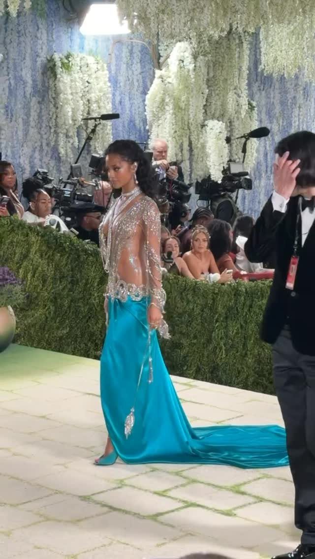 Woman in a silver beaded bodice and turquoise satin gown posing at event