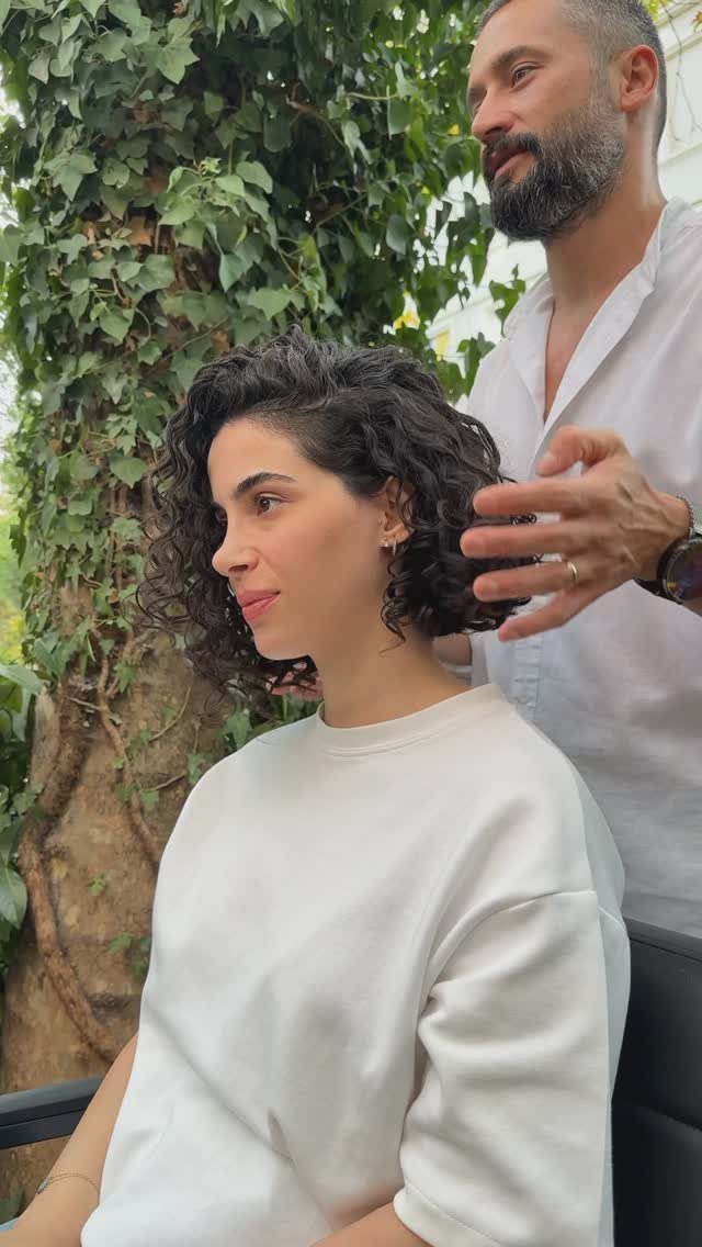 10 Natural Curls Hairstyles for Every Length and Style 6 Woman with a curly bob hairstyle being styled by a man outdoors.