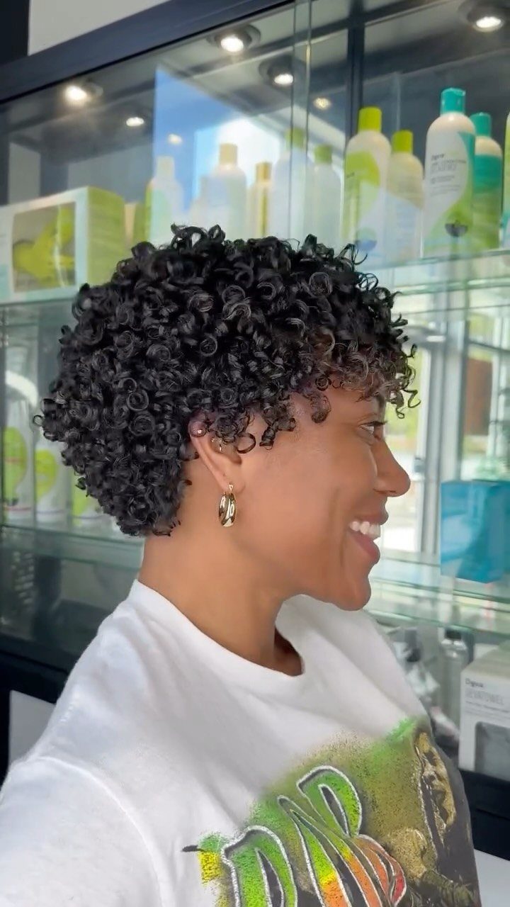 10 Natural Curls Hairstyles for Every Length and Style 3 Woman with a short curly pixie cut smiling in a hair salon