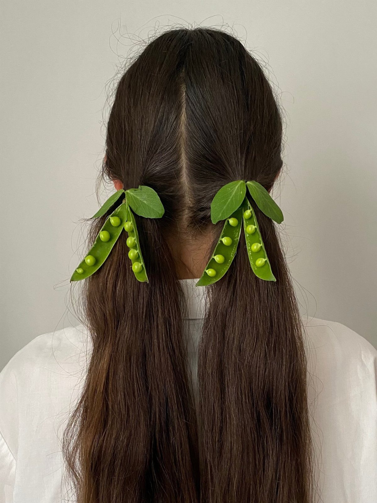 Natural Hair Beauty Looks: 11 Styles From Buns to Locs 11 Long brown hair styled in pigtails with green pea-pod shaped hair clips.