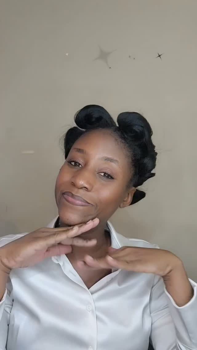Natural Hair Beauty Looks: 11 Styles From Buns to Locs 2 Woman with dark skin posing with her hair styled in glossy pin curls.