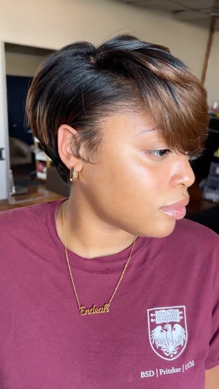 Natural Hair Beauty Looks: 11 Styles From Buns to Locs 8 Woman with a short dark pixie cut and brown highlights wearing a maroon shirt.