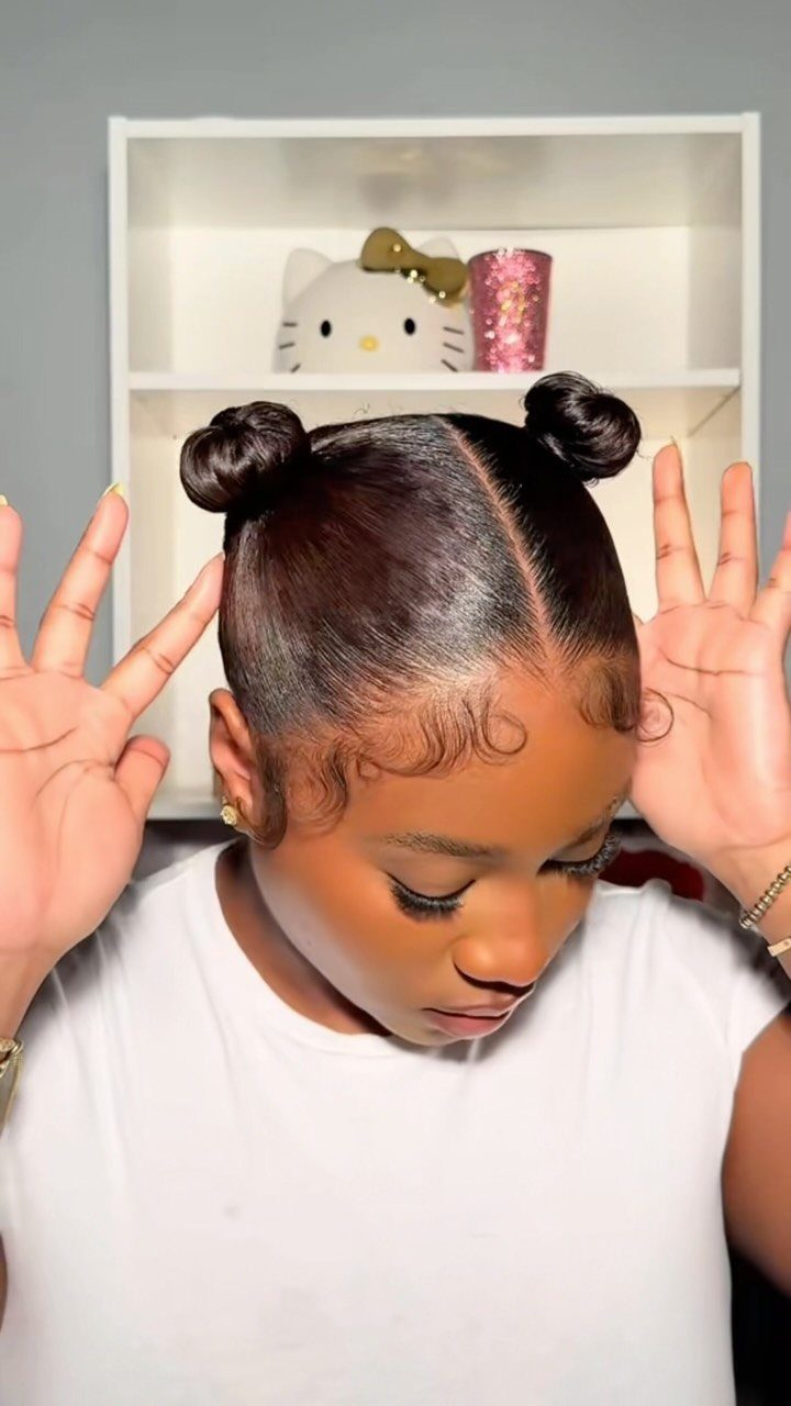 Natural Hair Beauty Looks: 11 Styles From Buns to Locs 5 Woman with dark hair styled in two space buns and curled edges.