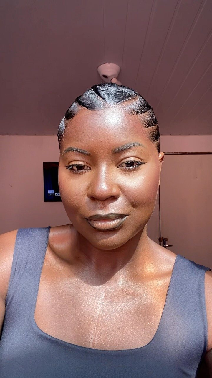 Black woman with short black hair styled in glossy, sculpted finger waves.