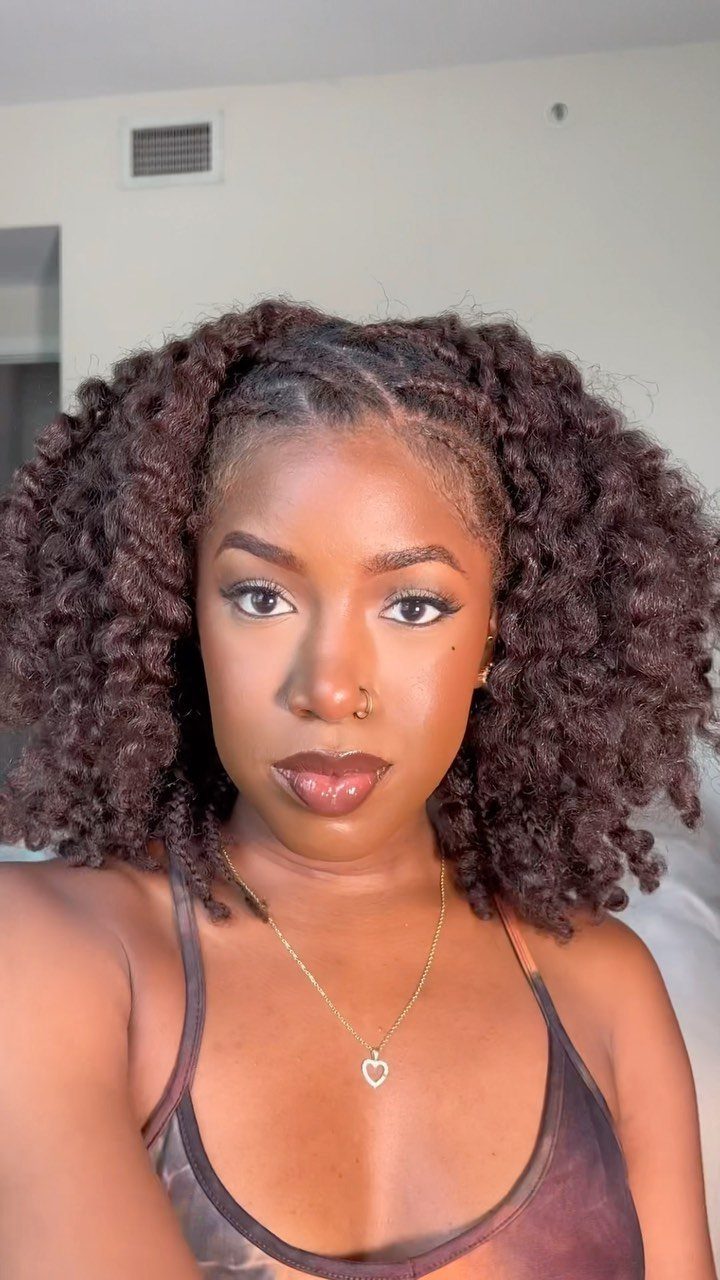 Woman with short, voluminous dark brown curly hair styled in a twist out.