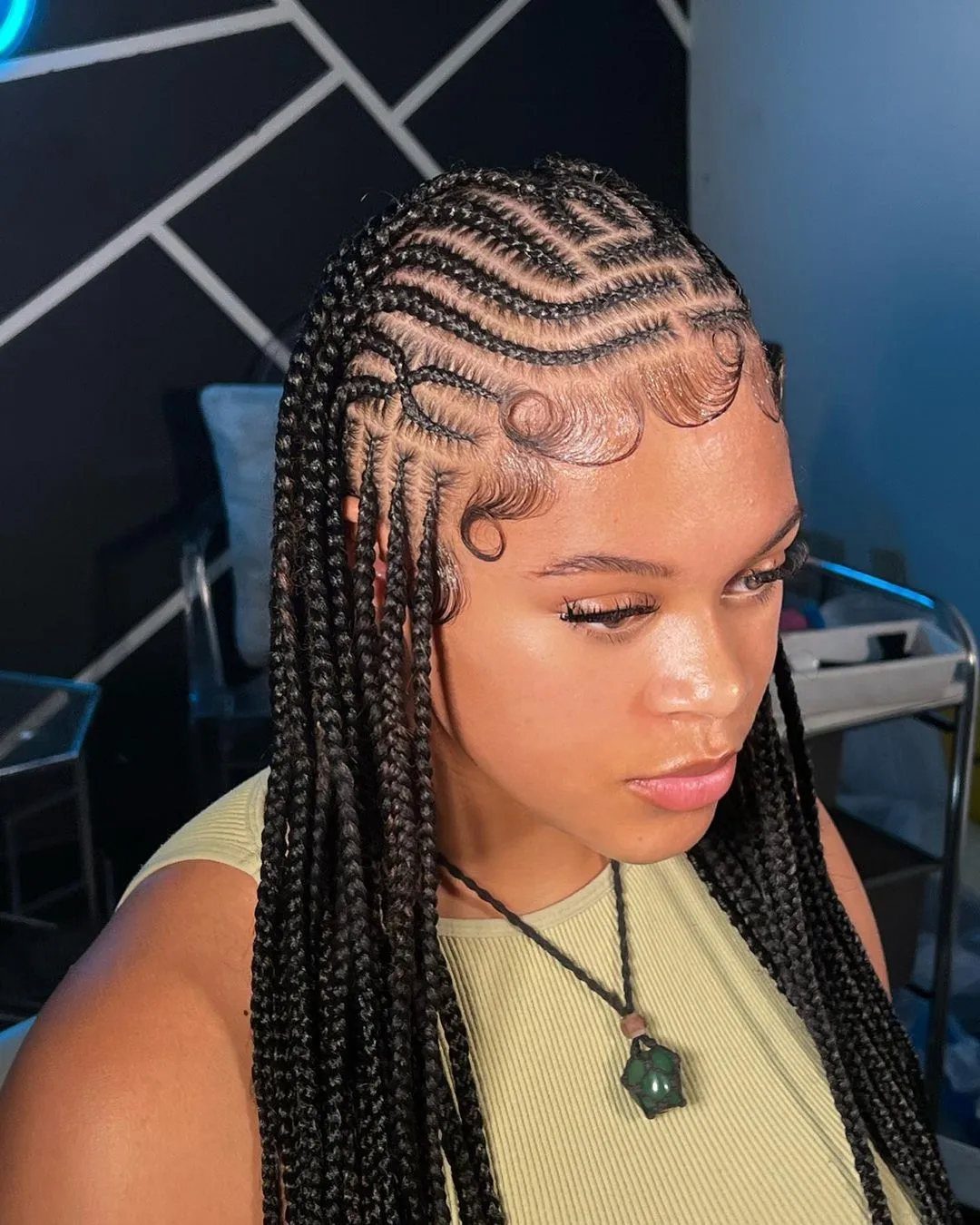 Woman with intricate Fulani braids featuring cornrow patterns and long hanging braids.