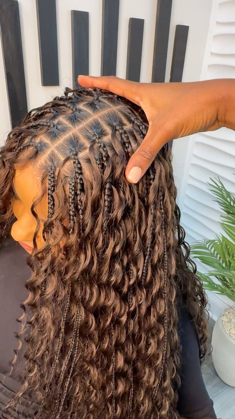 Woman with long brown goddess braids and curly strands, showing the scalp pattern.