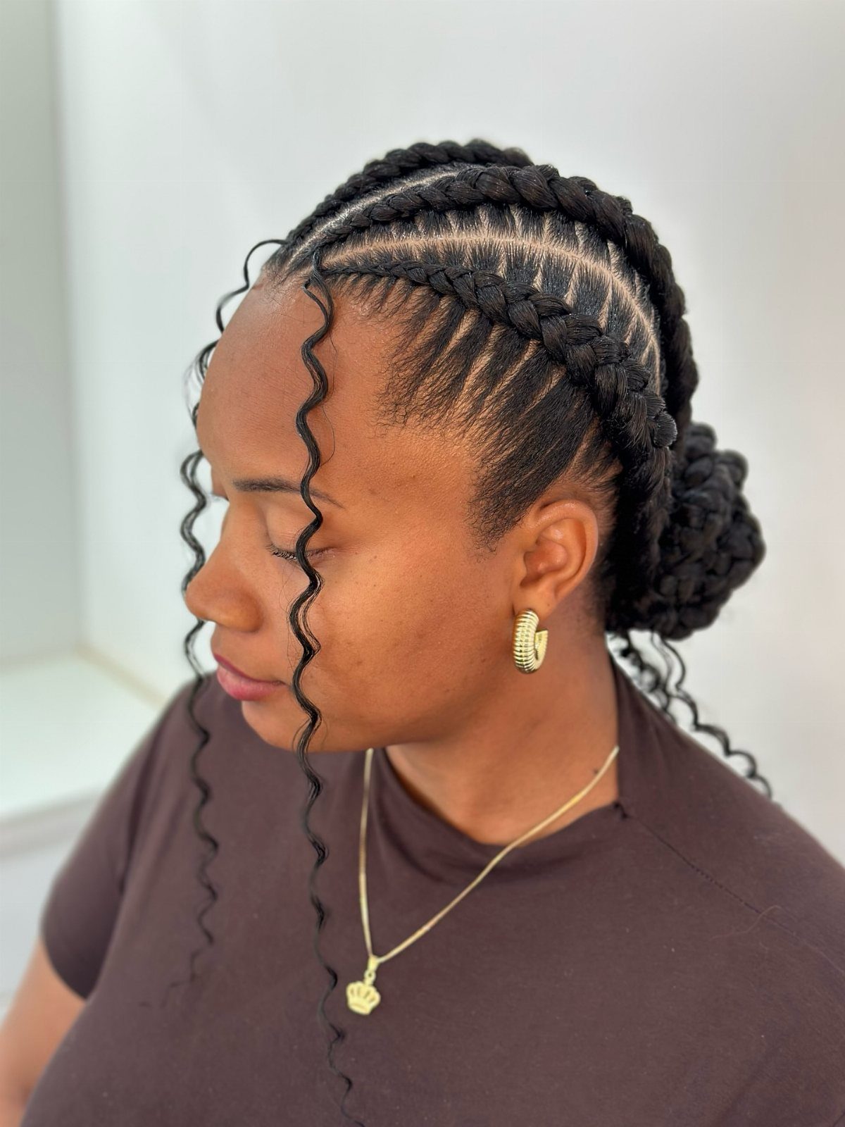 Woman with cornrows styled into a halo braid and a back bun.