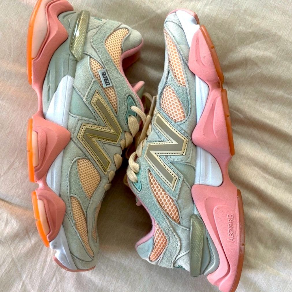 New Balance 9060 Pink and Blue Sneakers: 6 Ideas 2 New Balance 9060 sneakers in pink and blue resting on beige fabric.