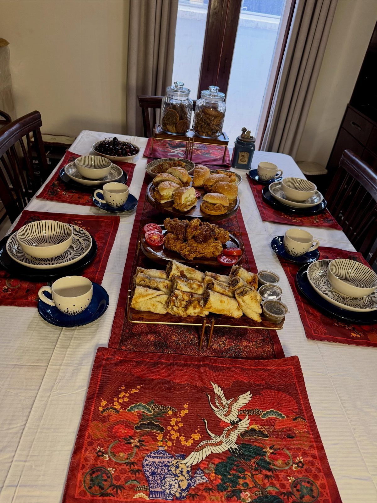 Dining table set with red runners and platters of breakfast and brunch foods.