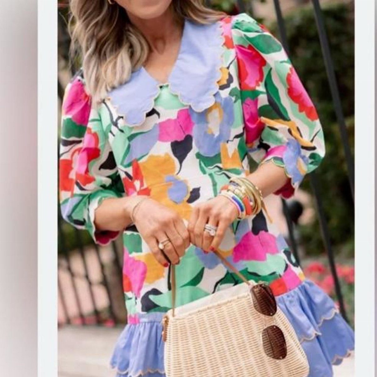 Woman wearing a colorful floral printed dress with a light blue scalloped collar