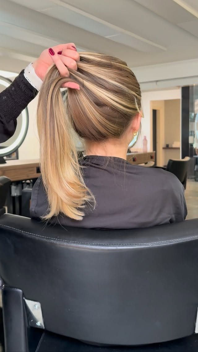 Woman with butter blonde hair tied in a high ponytail at a salon