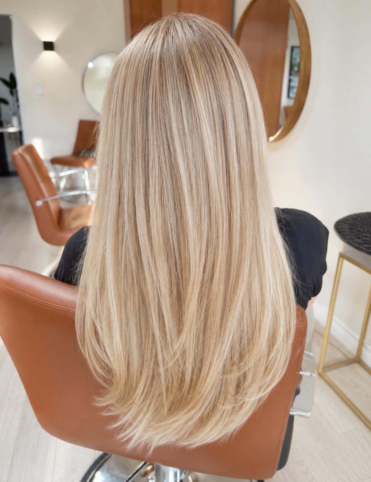 Long straight champagne blonde hair seen from behind in a hair salon
