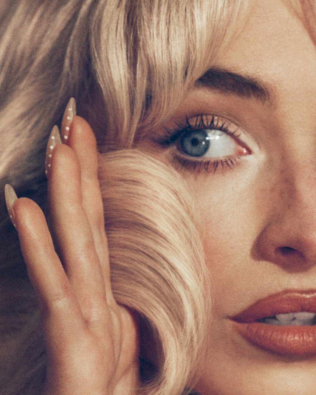 Woman with shimmering pearly blonde hair and blue eyes looking at camera