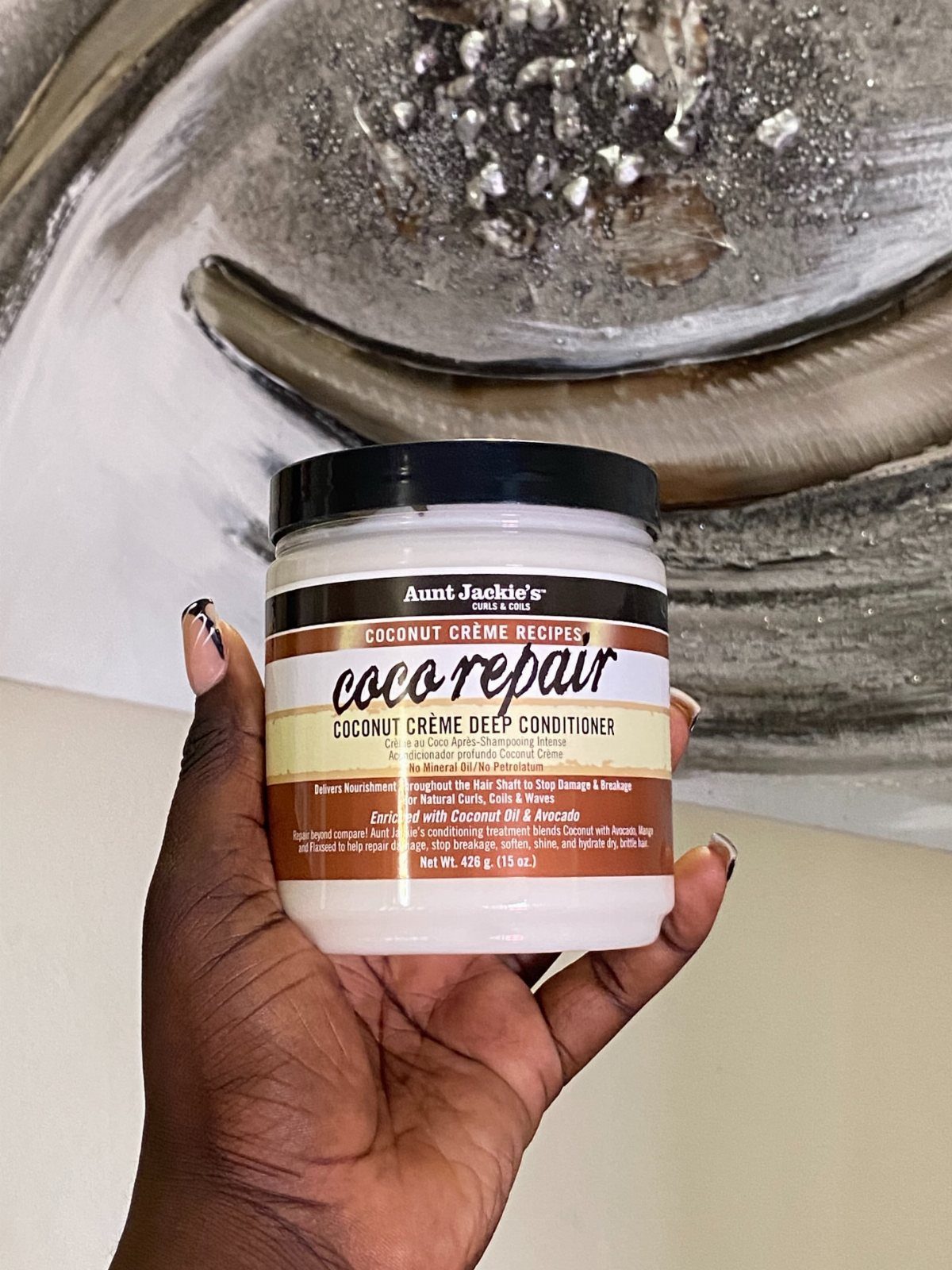 7 Products for Healthy Hair: Scalp Care to Deep Conditioners 7 Hand holding a jar of coconut crème deep conditioner for healthy hair care.