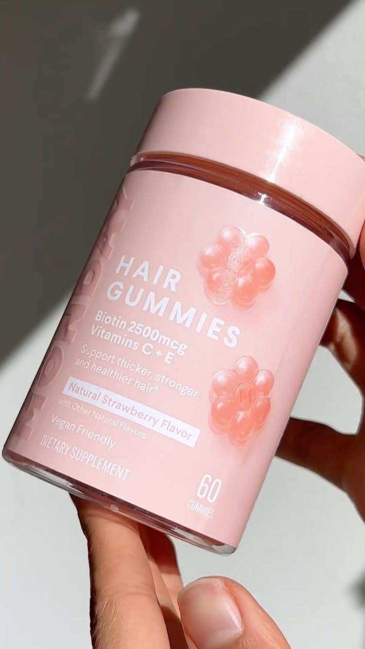 7 Products for Healthy Hair: Scalp Care to Deep Conditioners 3 Pink bottle of hair gummies held by a hand against a light background