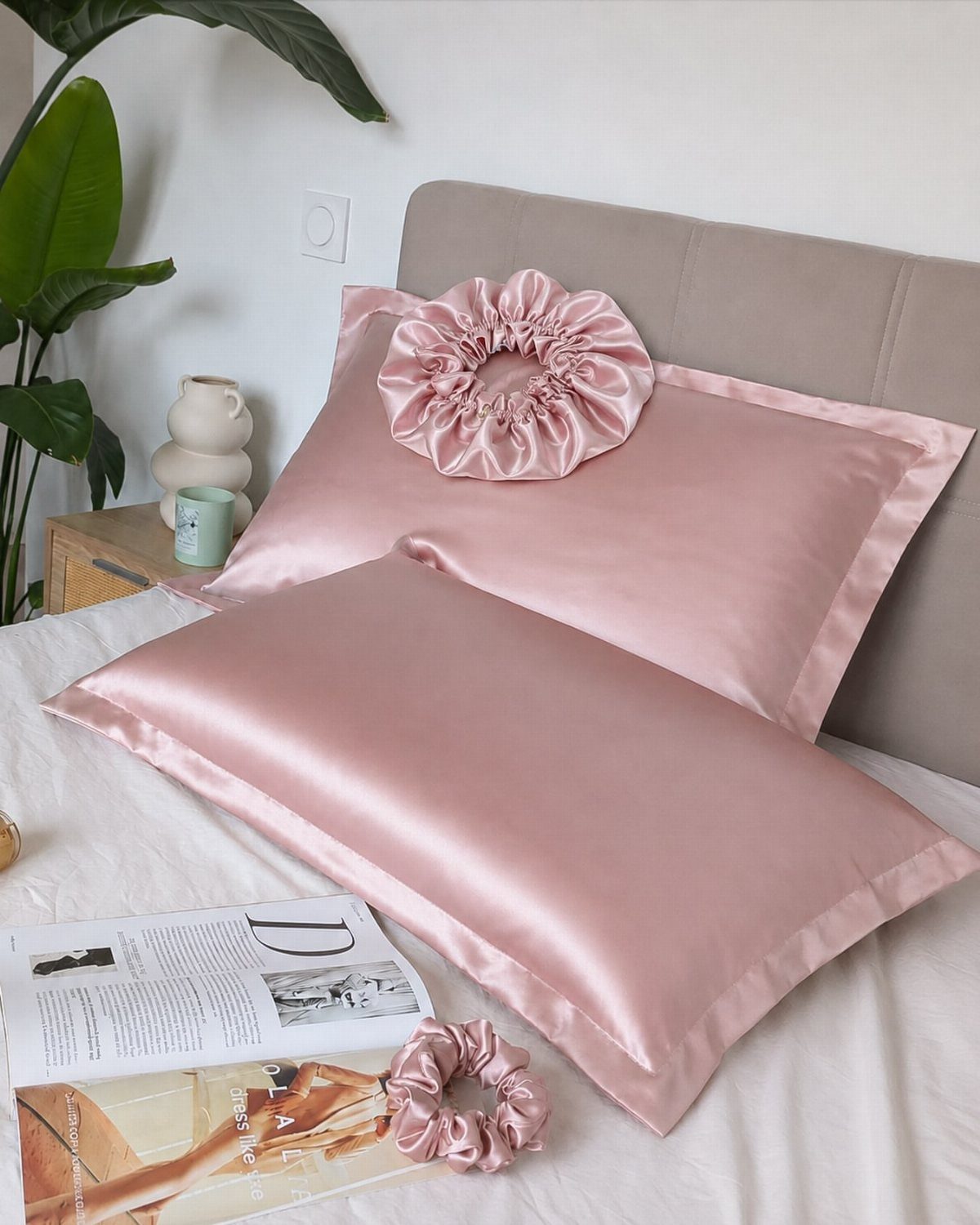 7 Products for Healthy Hair: Scalp Care to Deep Conditioners 5 Pink satin pillowcases and matching scrunchies on a bed with a grey headboard.