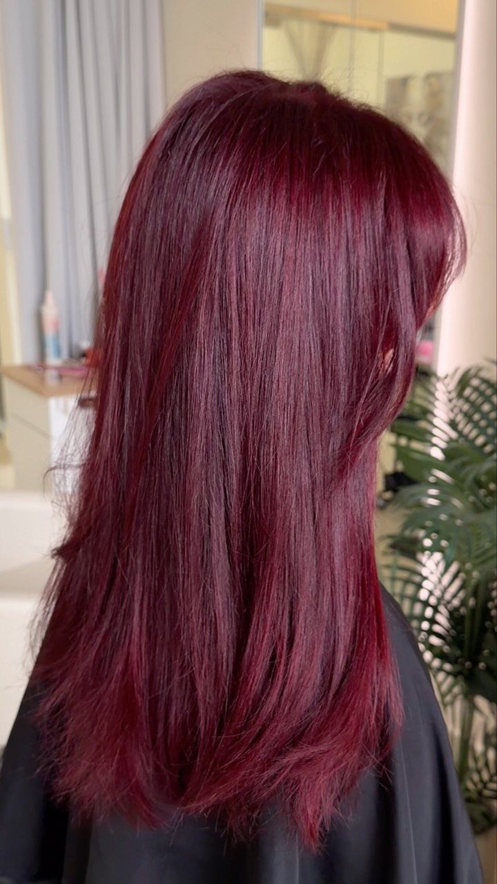 13 Red Undertones Hair Ideas, From Copper to Burgundy 7 Long straight hair dyed a vivid cherry red color over a black cape.
