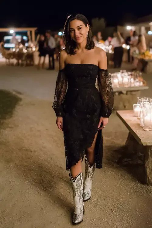 Woman in black lace midi dress and white cowboy boots at night event