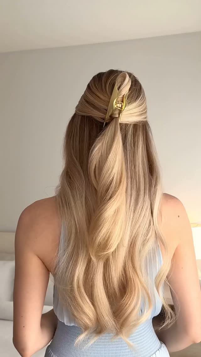 8 Simple Half Up Hairstyles for Every Occasion 6 Long wavy blonde hair styled in a half-updo secured with a gold claw clip.