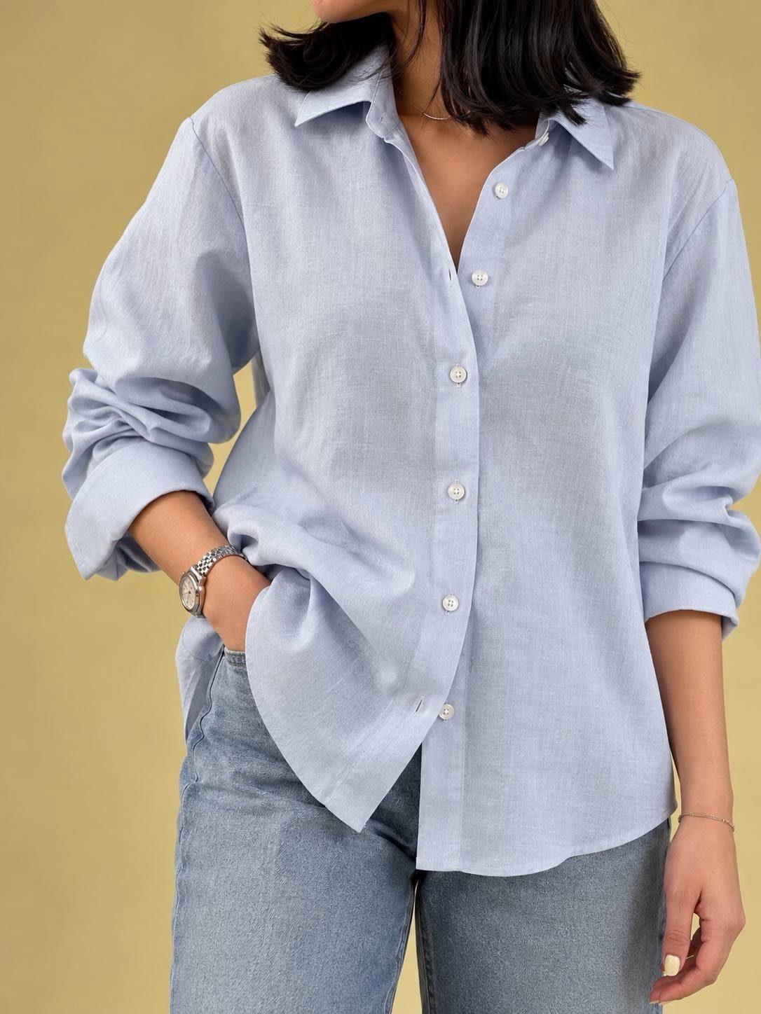 Light blue linen button-down shirt paired with light wash blue jeans.