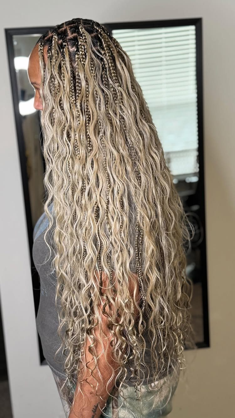 Long blonde bohemian knotless box braids with curly loose strands on a person.