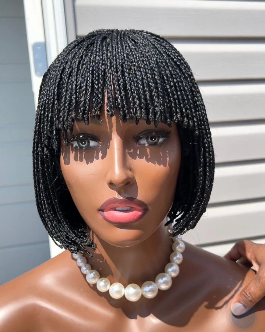 Mannequin wearing a box braid bob with a full braided fringe and pearls