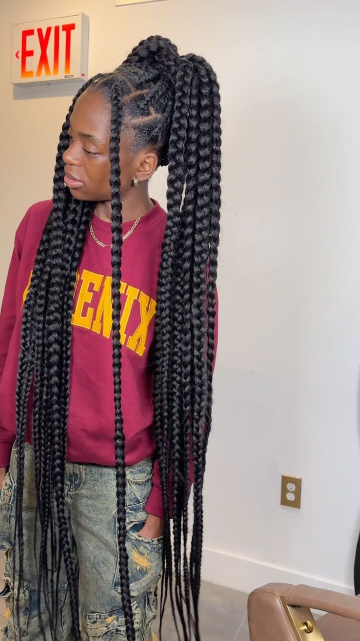 Person with long black box braids styled in a high ponytail wearing maroon sweatshirt