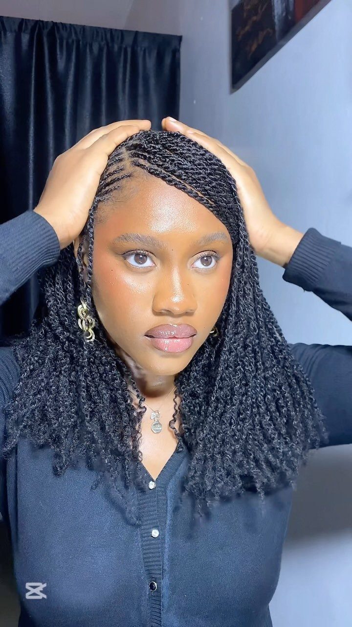 Woman with black braided hair styled in a side part and loose curls.