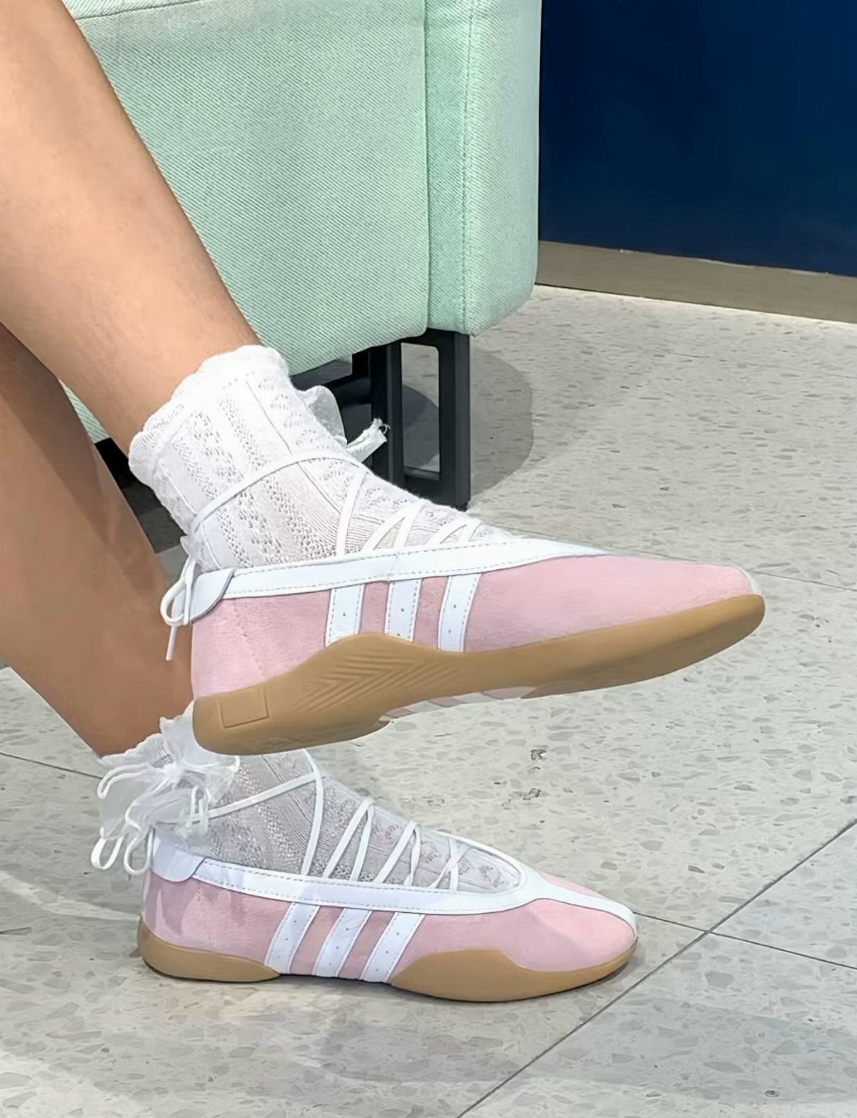 Pink taekwondo lace shoes with white stripes and laces wrapped around the ankles.