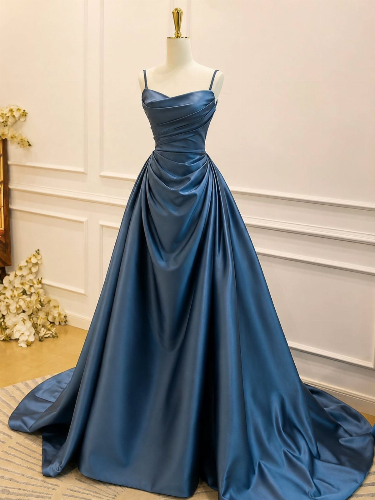 Blue satin floor-length gown with ruched bodice on a white mannequin
