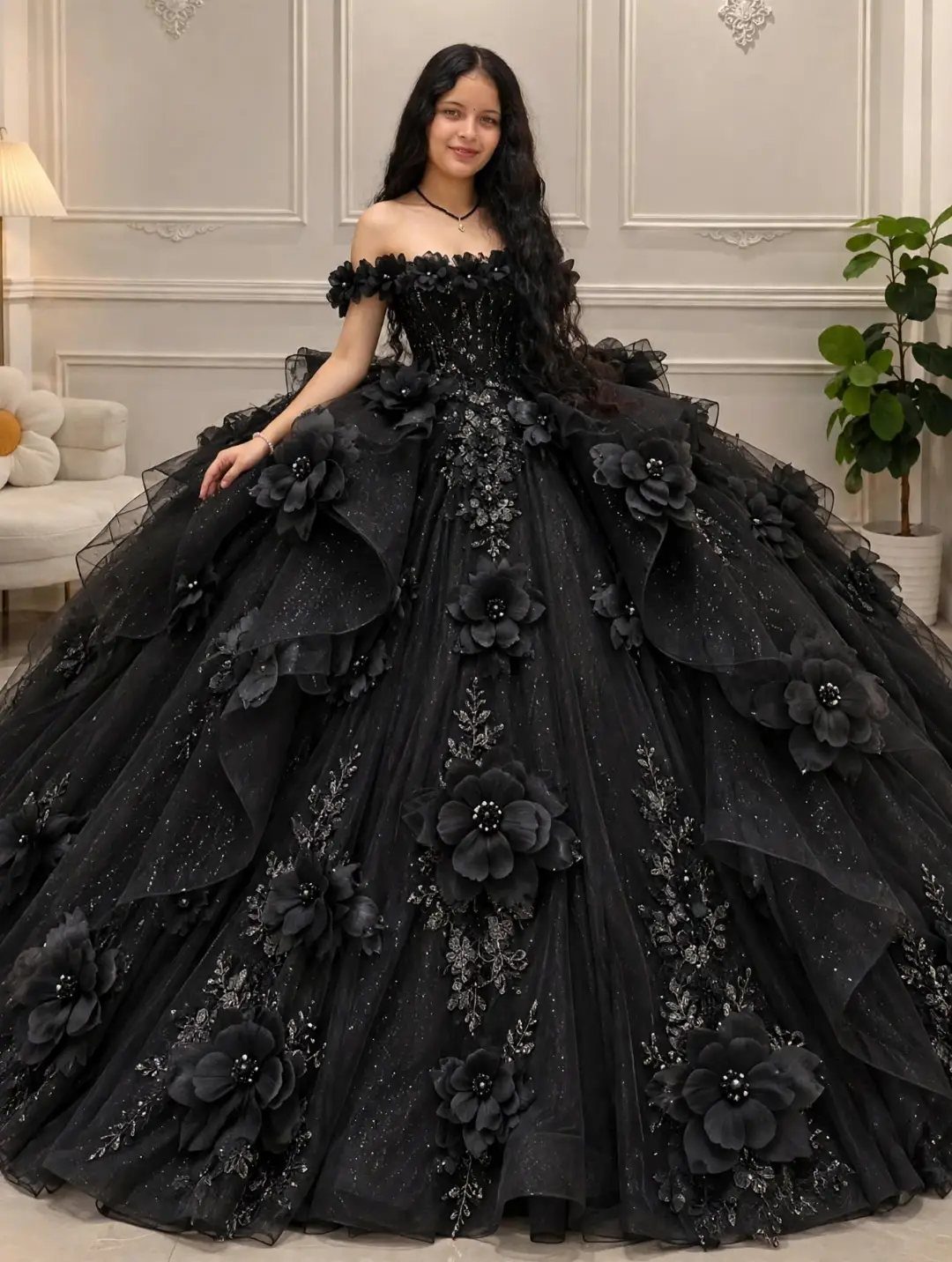 Woman wearing a voluminous strapless black ballgown with 3D floral details and sparkles.