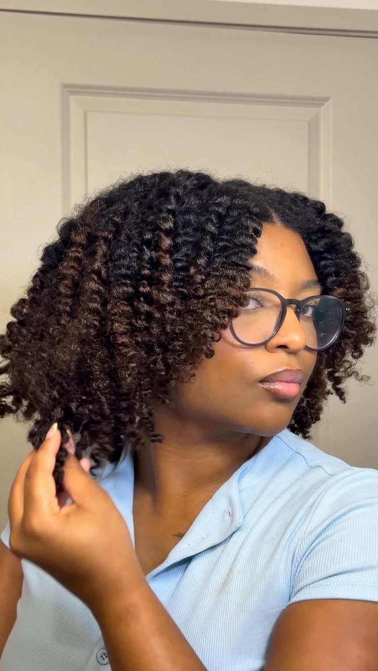6 Twist Outs on 4c Hair Ideas for Every Look and Length 5 Woman with defined curly twist-outs wearing glasses and a light blue shirt.