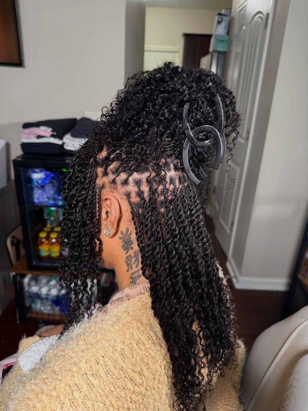 Two Strand Twist Natural Hair Women: 10 Style Ideas 4 Woman with long black two-strand twists held up by a black claw clip