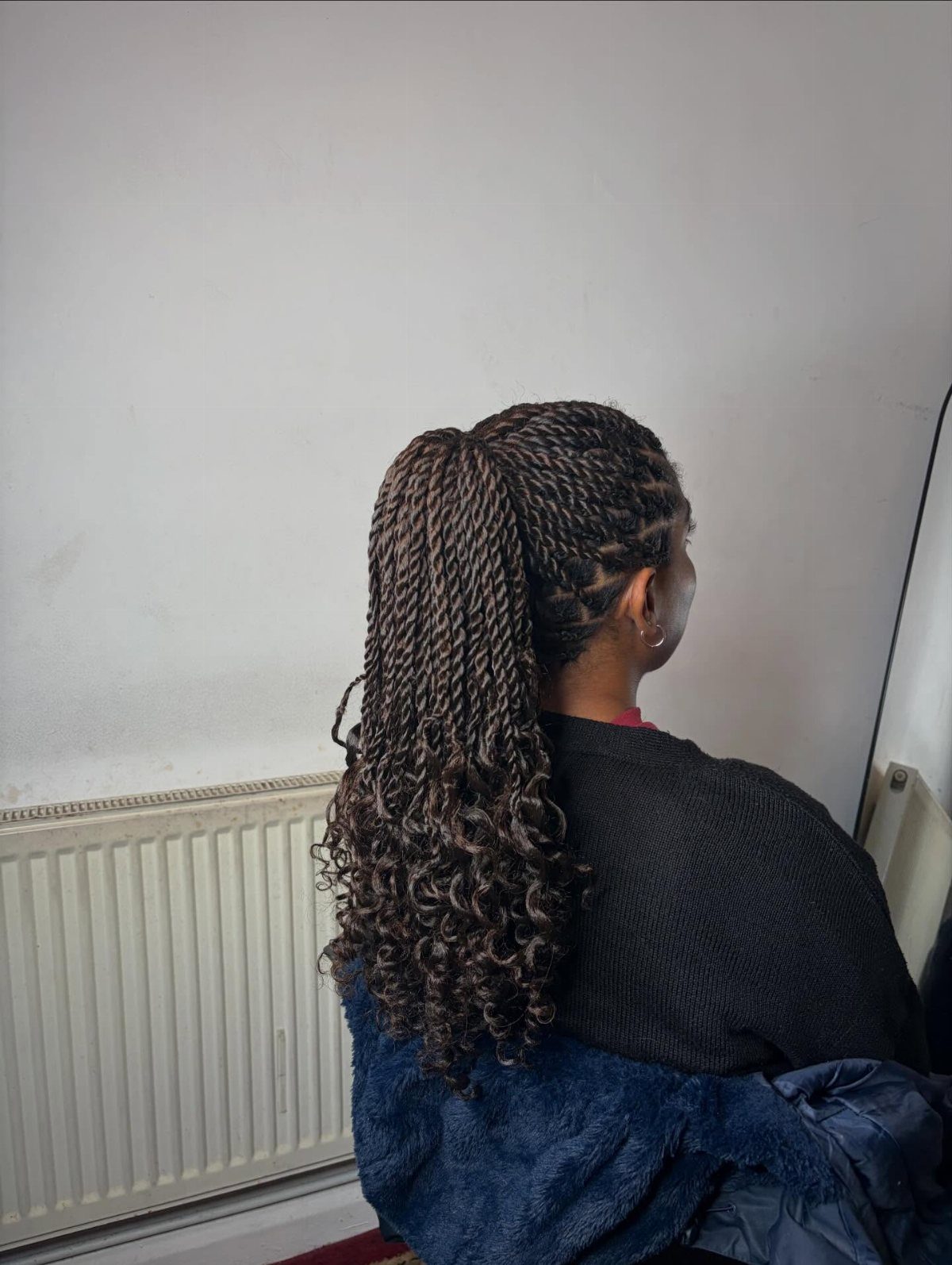 Two Strand Twist Natural Hair Women: 10 Style Ideas 10 Woman with two-strand twists styled in a high ponytail with curly ends.