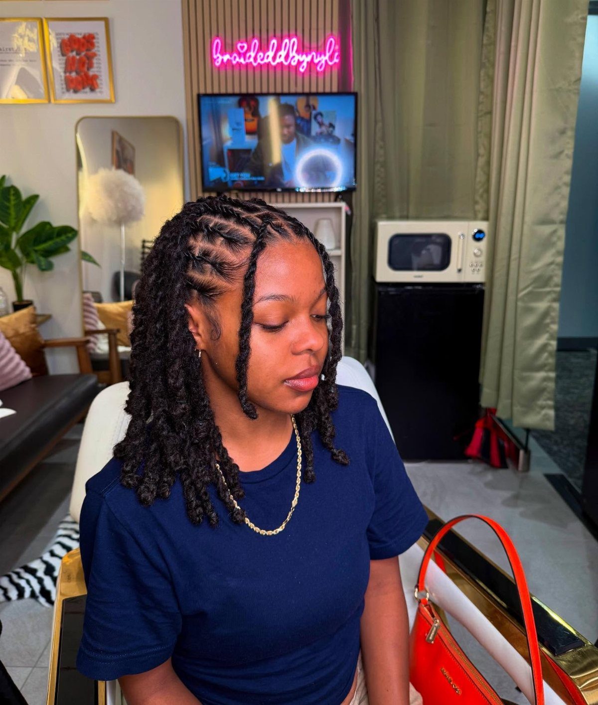 Two Strand Twist Natural Hair Women: 10 Style Ideas 1 Woman with dark skin showcasing a two-strand twist protective hairstyle in a salon.