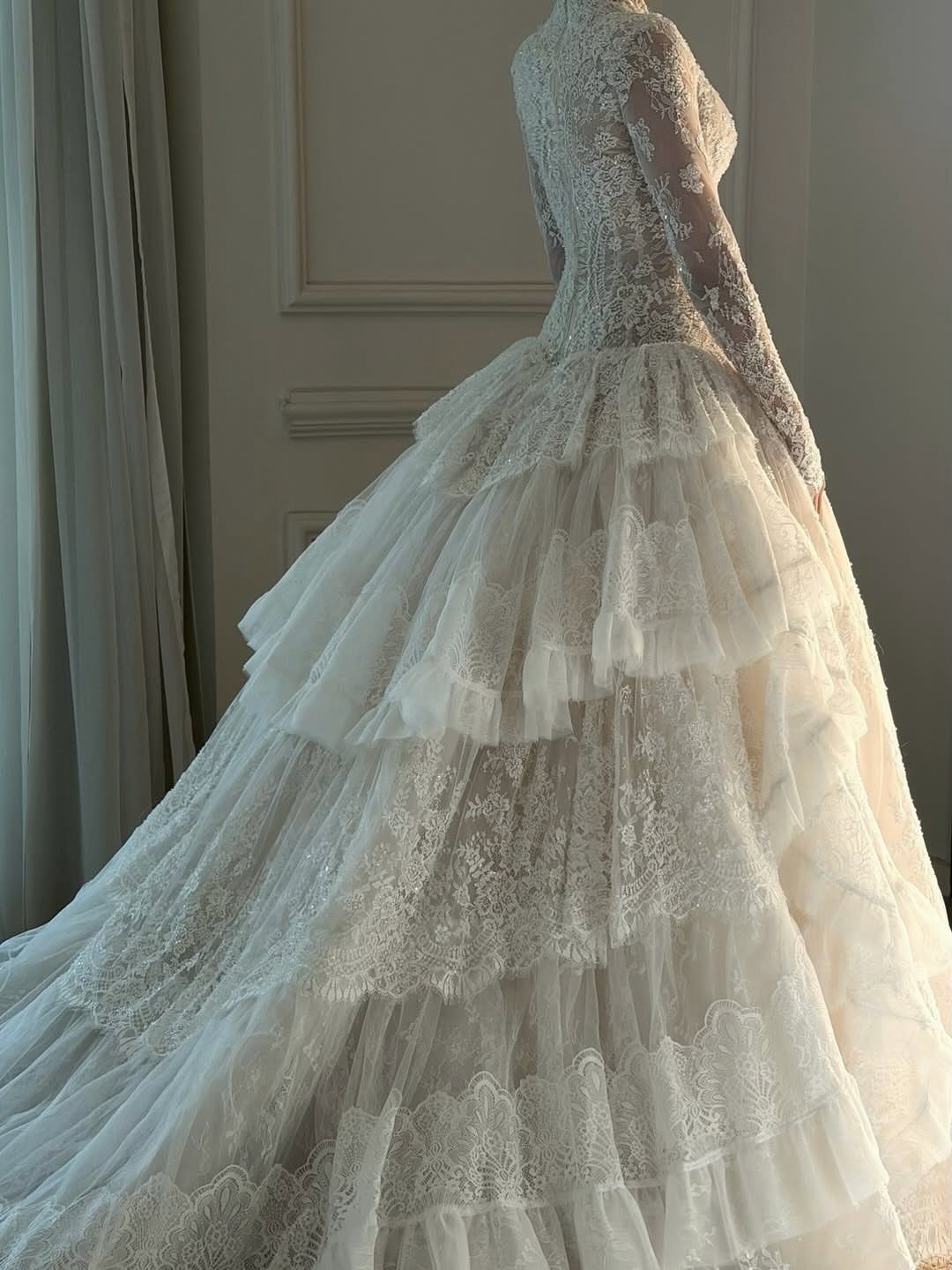 Woman in a white lace wedding dress with a voluminous tiered flowy skirt