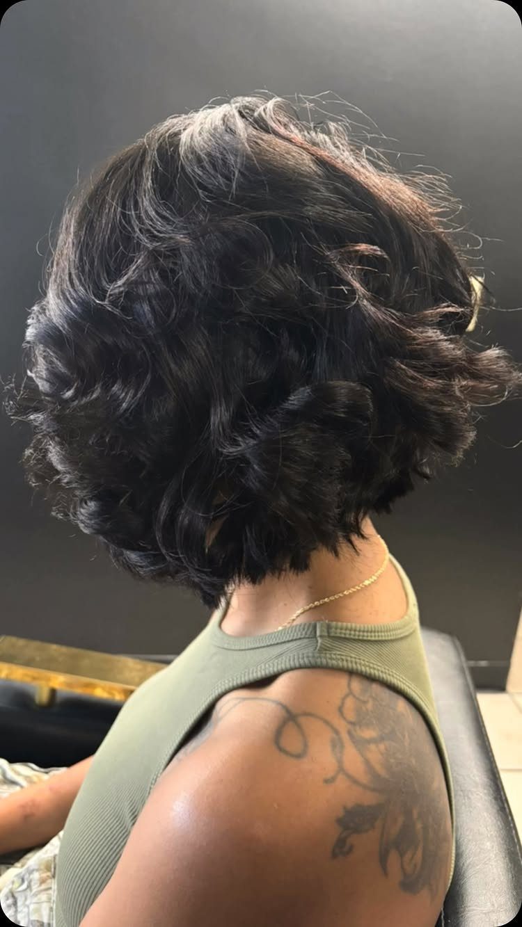 Dark wavy chin-length bob haircut seen from the back on a person.