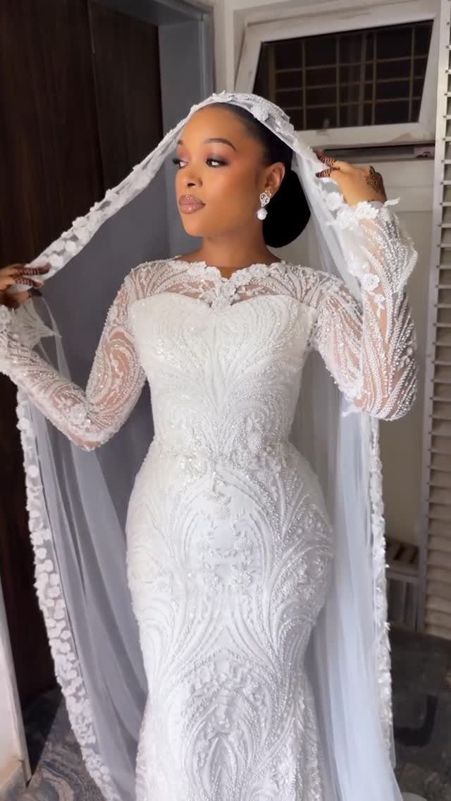 Wedding Dresses Off White: 9 Ideas for Every Bride 8 Woman in a long-sleeved off-white lace wedding dress and a sheer bridal veil.