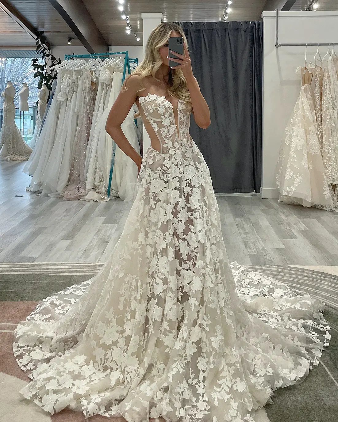 Wedding Dresses Off White: 9 Ideas for Every Bride 3 Woman wearing an off-white wedding gown with 3D floral lace in a boutique
