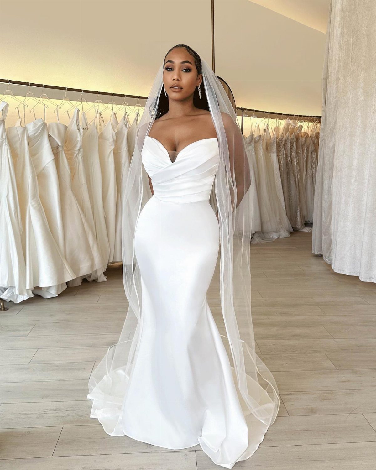 Wedding Dresses Off White: 9 Ideas for Every Bride 2 Woman in a strapless off-white satin bridal gown and veil in a boutique