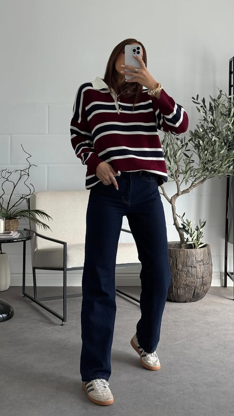 13 Winter Wear Ideas for Women: Coats, Knits and Boots 9 Woman wearing a striped sweater and dark-wash wide-leg jeans in a bright room.