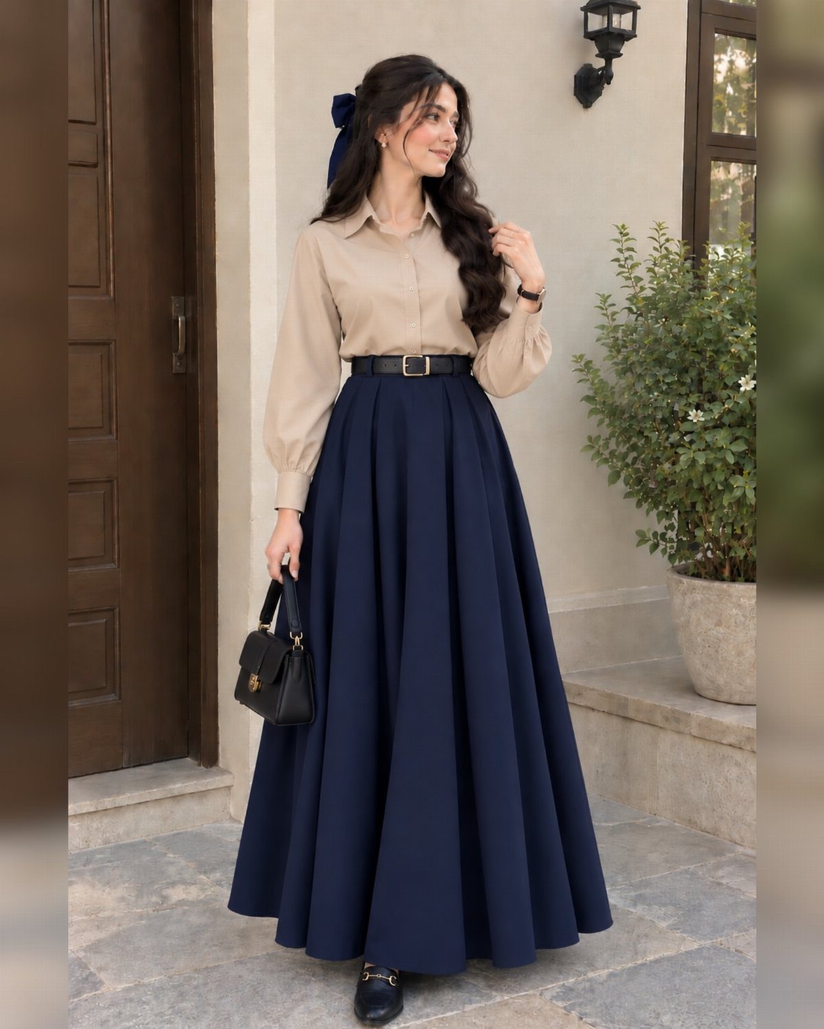 14 Women Skirt Outfits for Every Season and Occasion 13 Woman wearing a beige shirt and long navy blue pleated skirt with black belt