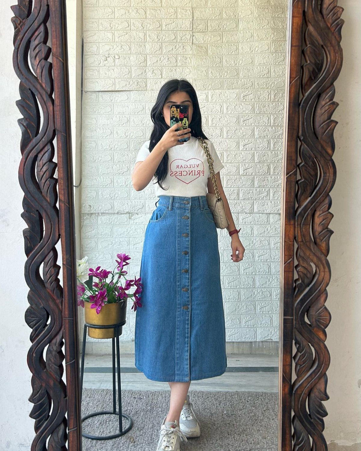 14 Women Skirt Outfits for Every Season and Occasion 6 Woman wearing a blue denim midi skirt and white t-shirt in a mirror selfie